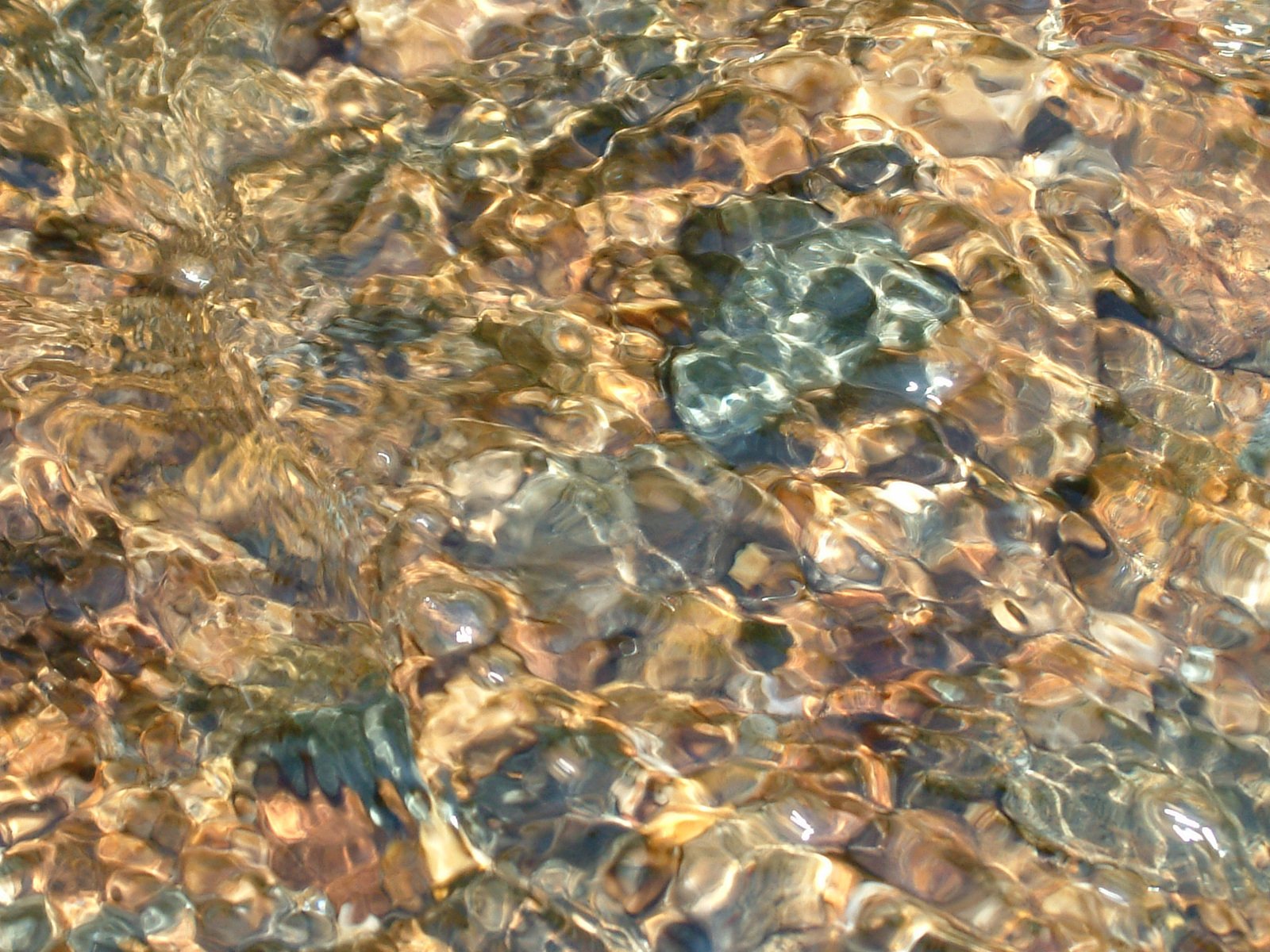 the water has ripples through the rocks on it