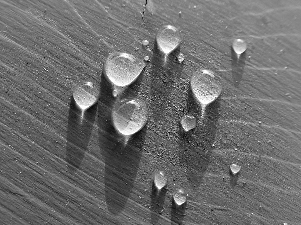 several drops of water on the side of a wooden surface