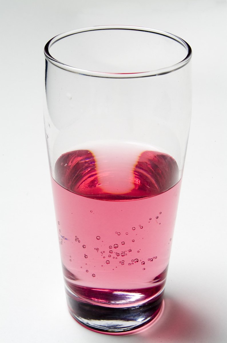 a close up of a pink liquid in a glass