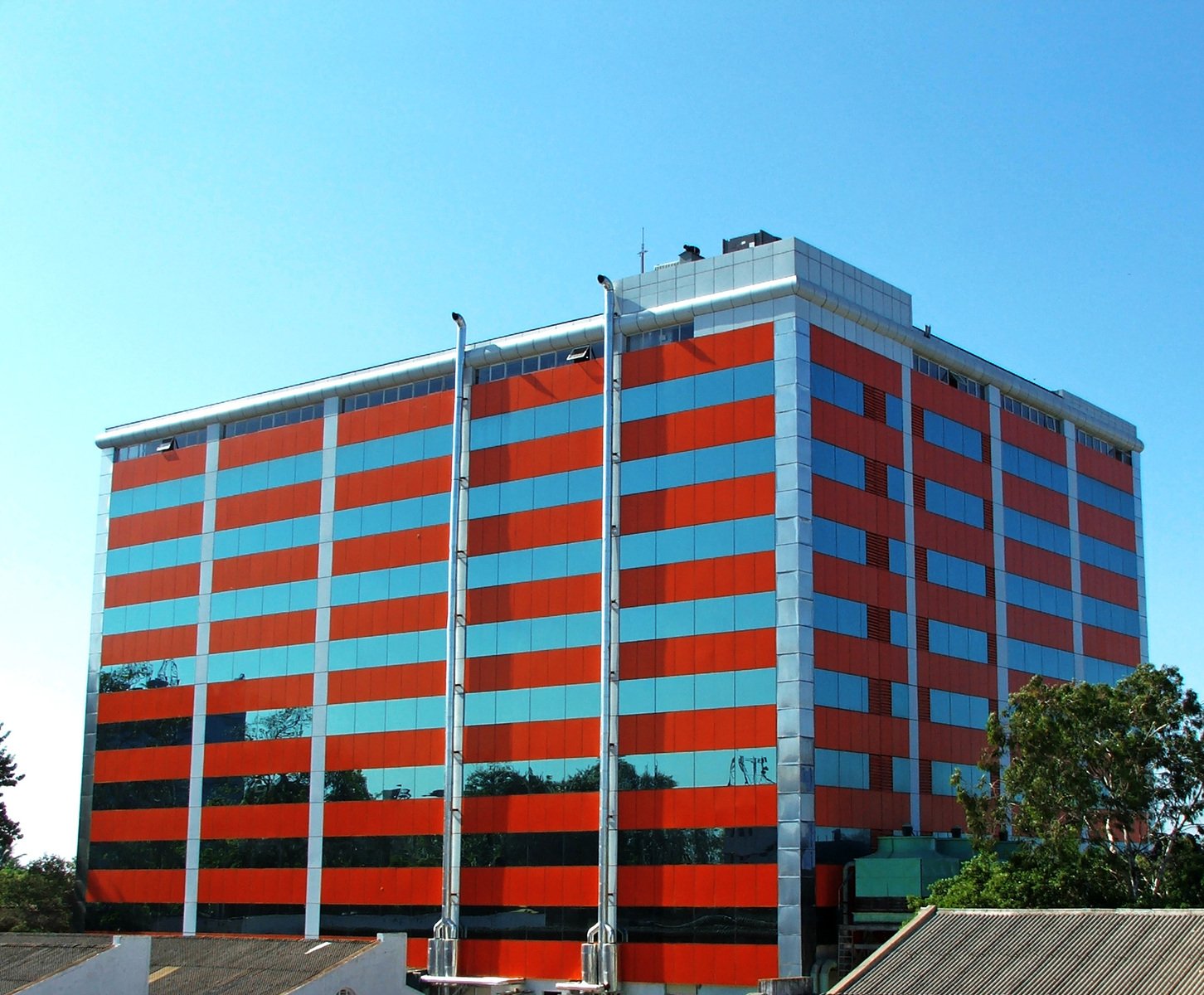 the tall building has bright orange and blue windows