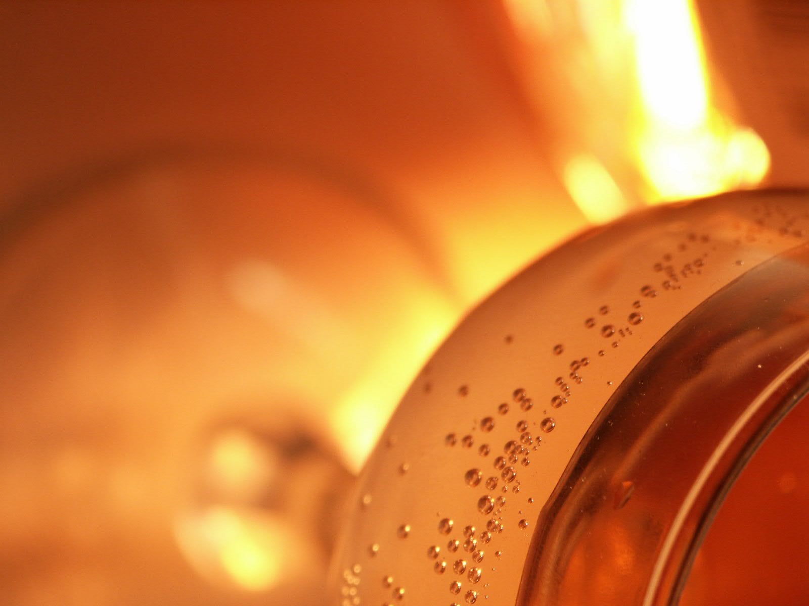 an iced beverage in a pitcher in front of a lit candle