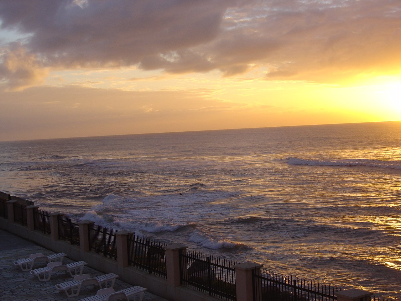 chairs near the ocean on an overcast evening