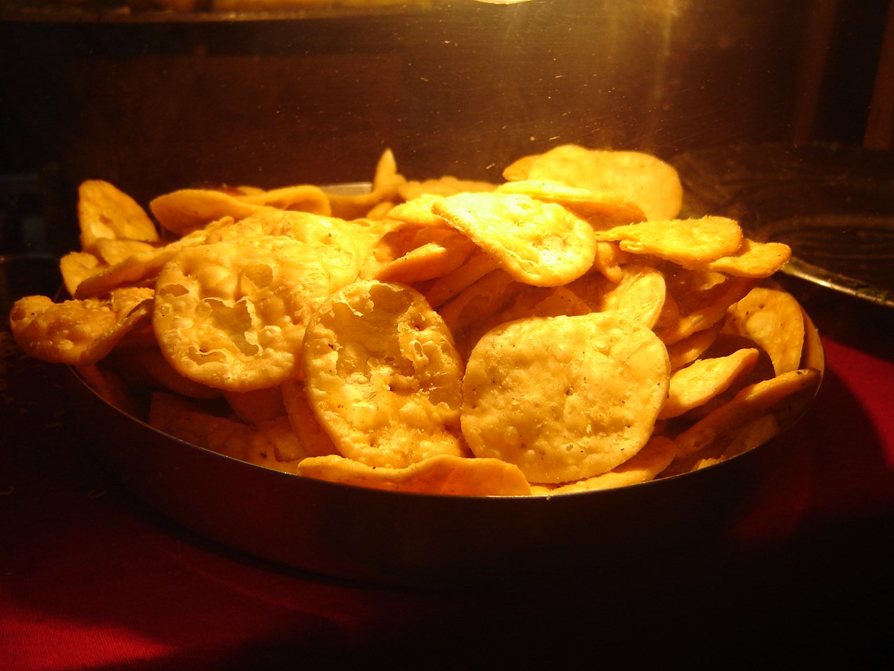 a metal bowl filled with lots of potato chips