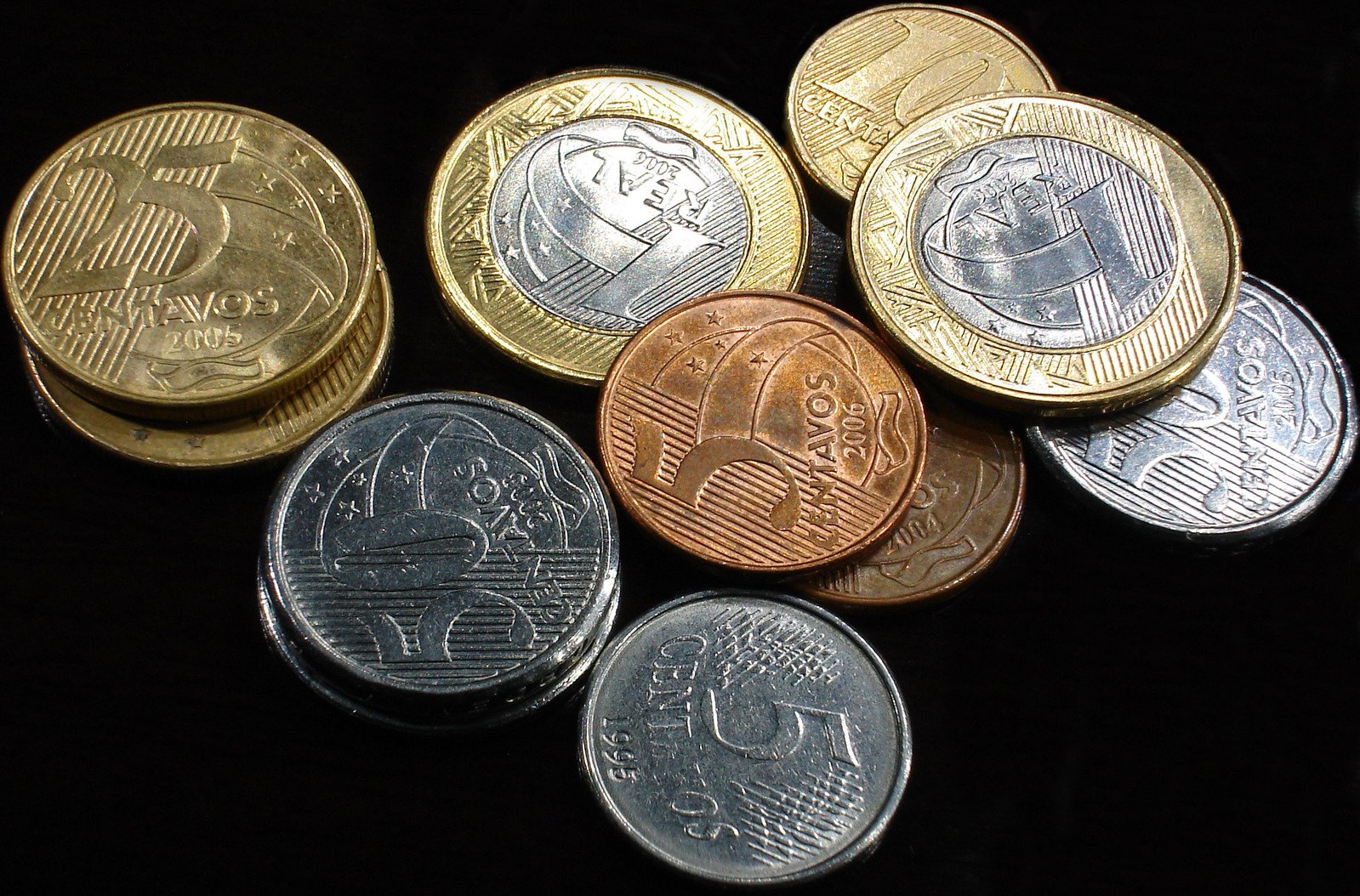 ten different british pound coins arranged in rows