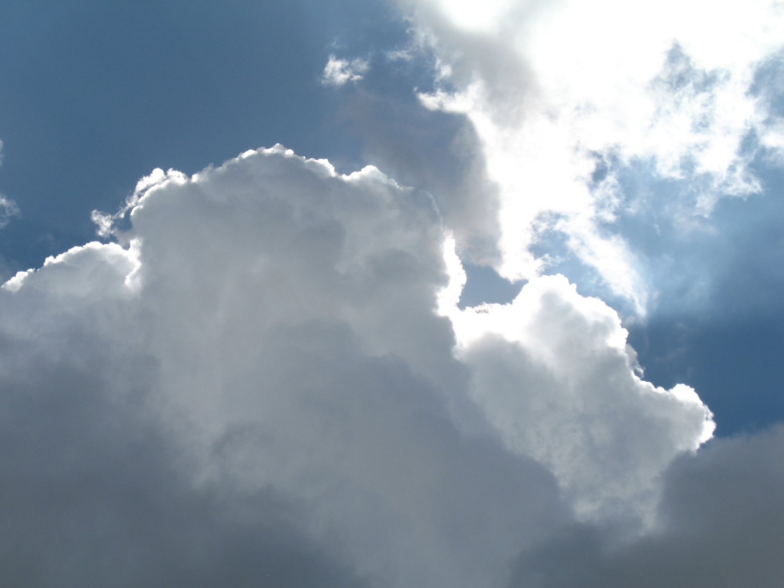 a large cloud is in the blue sky