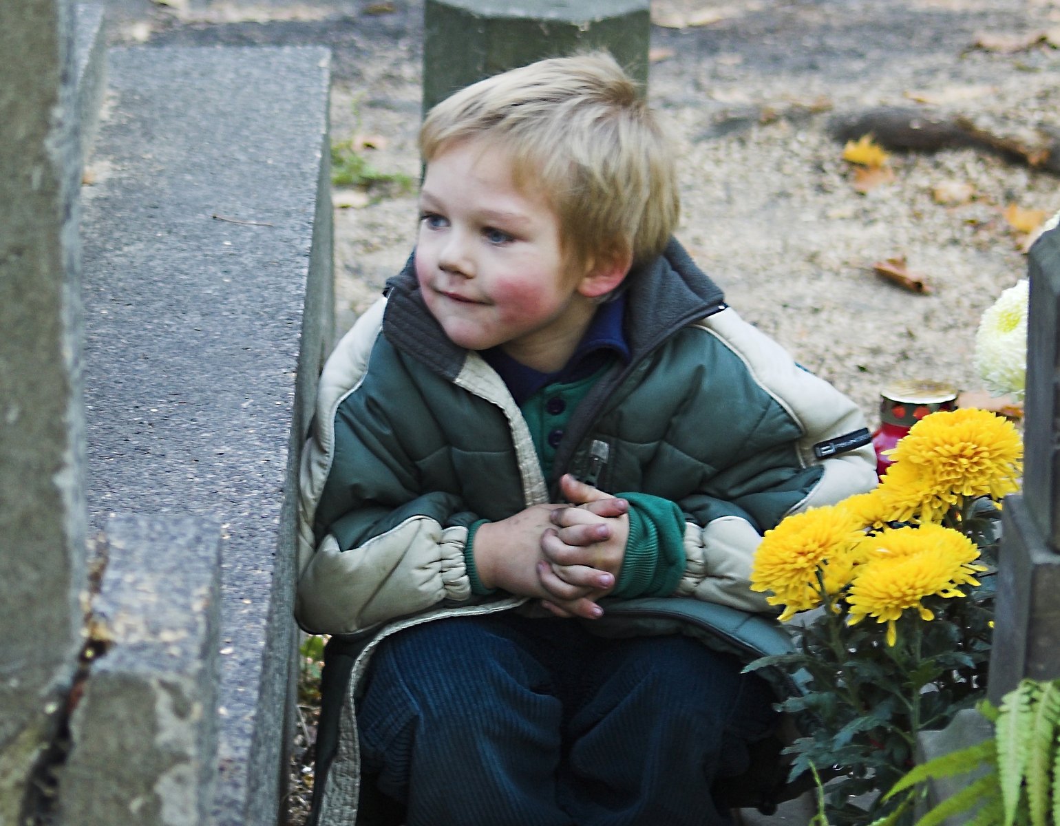 a boy is sitting outside holding a flower pot