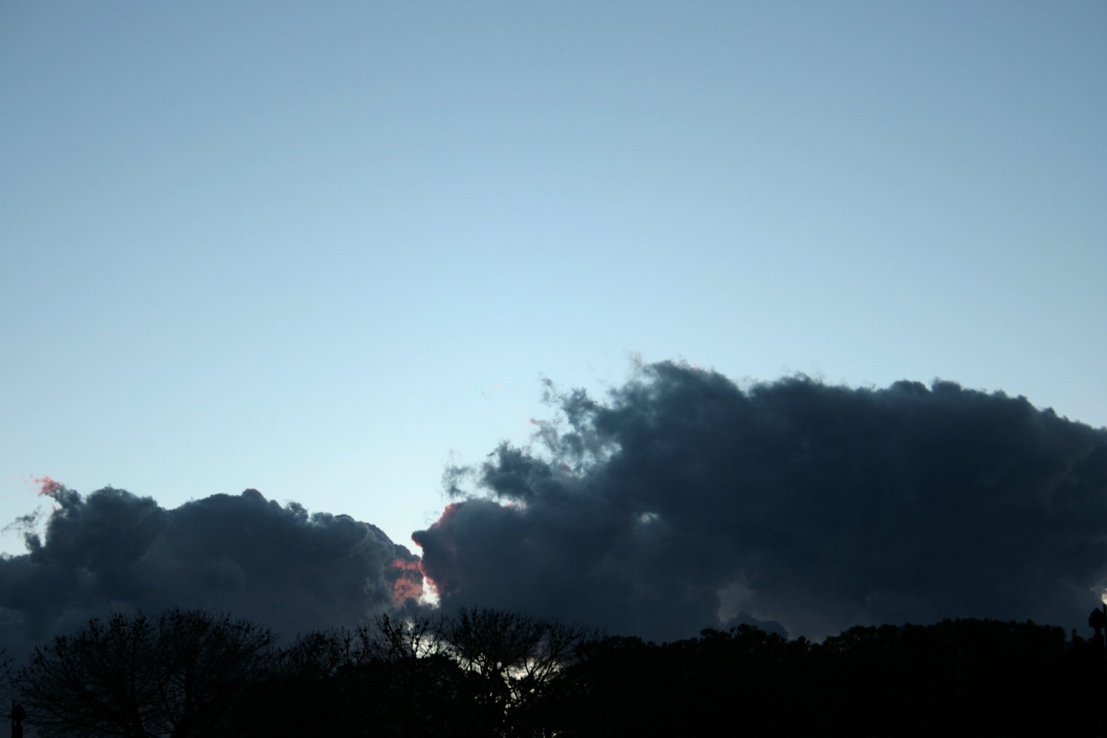 there are black clouds in the blue sky