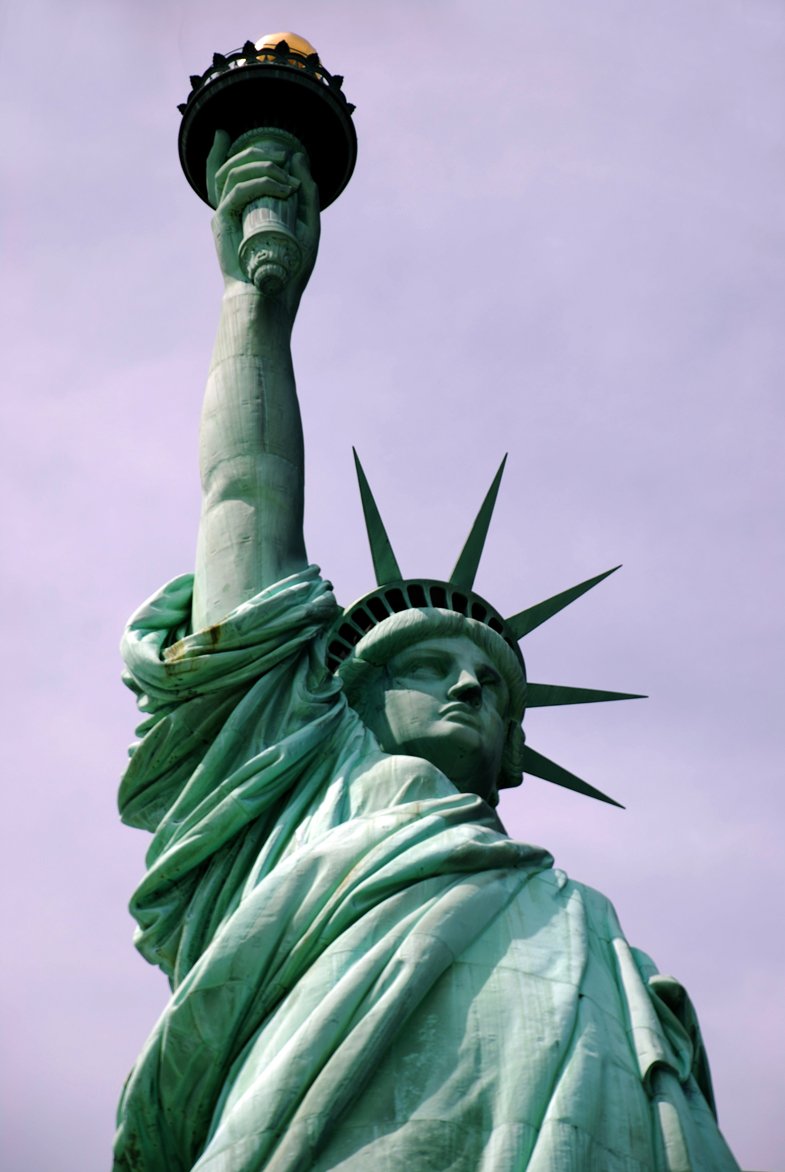 the statue of liberty is shown against a purple sky