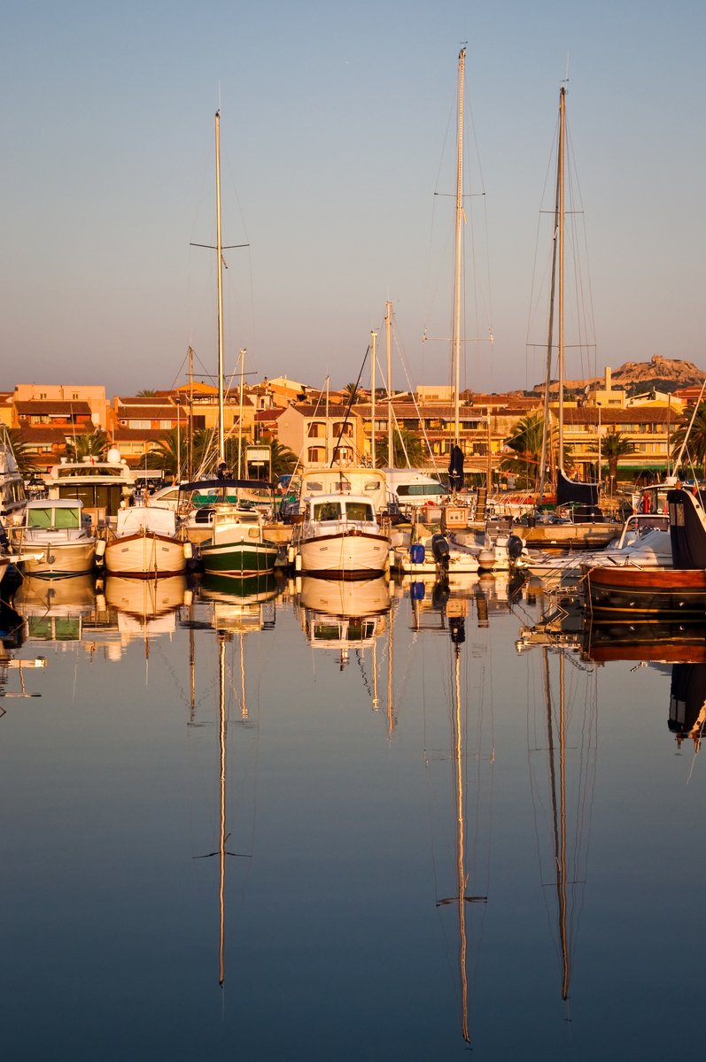 a bunch of small boats in the harbor at dusk