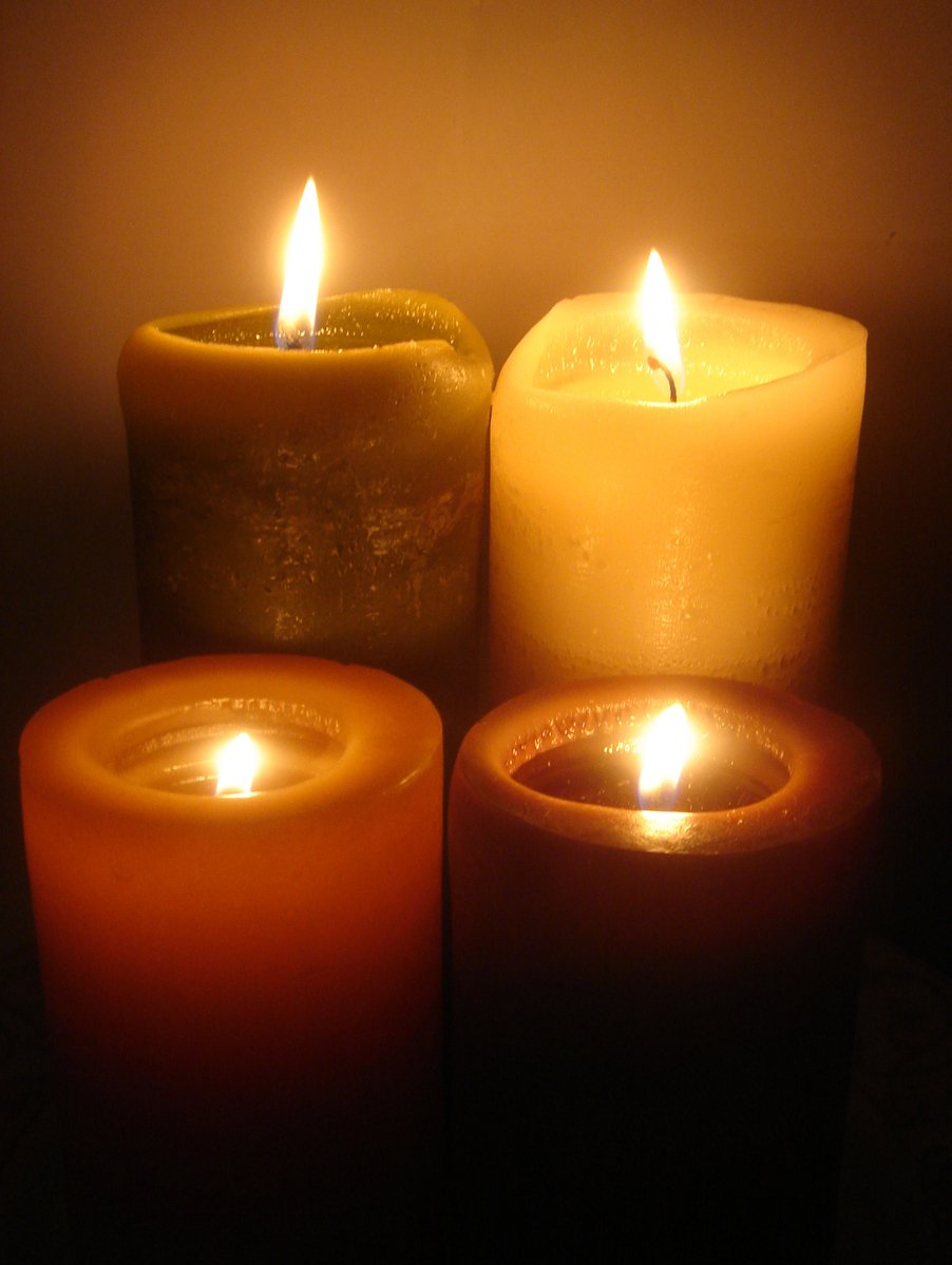 there are three lit candles of different colors