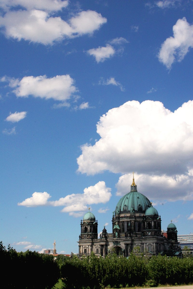 clouds gather in the blue sky above a palace