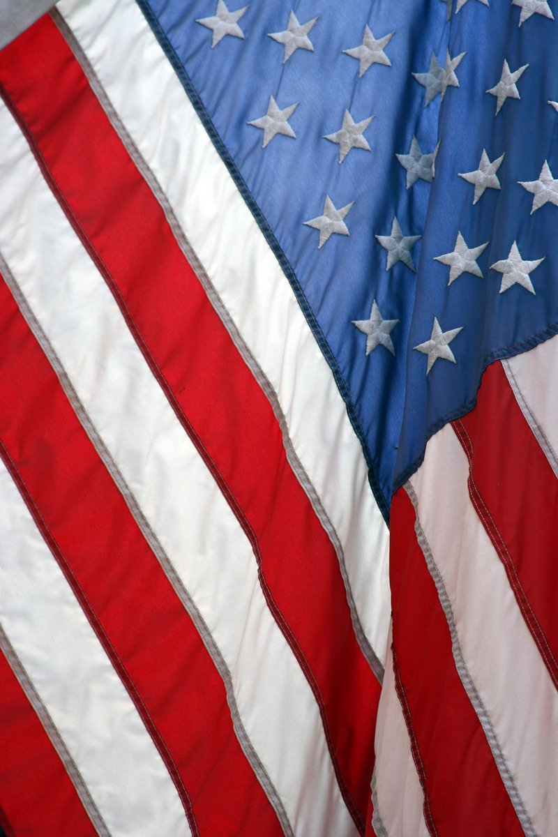 an american flag is displayed as well as a large white and red striped flag