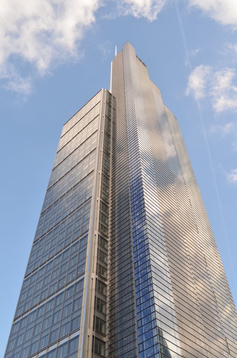 a glass skyscr is seen against a blue sky