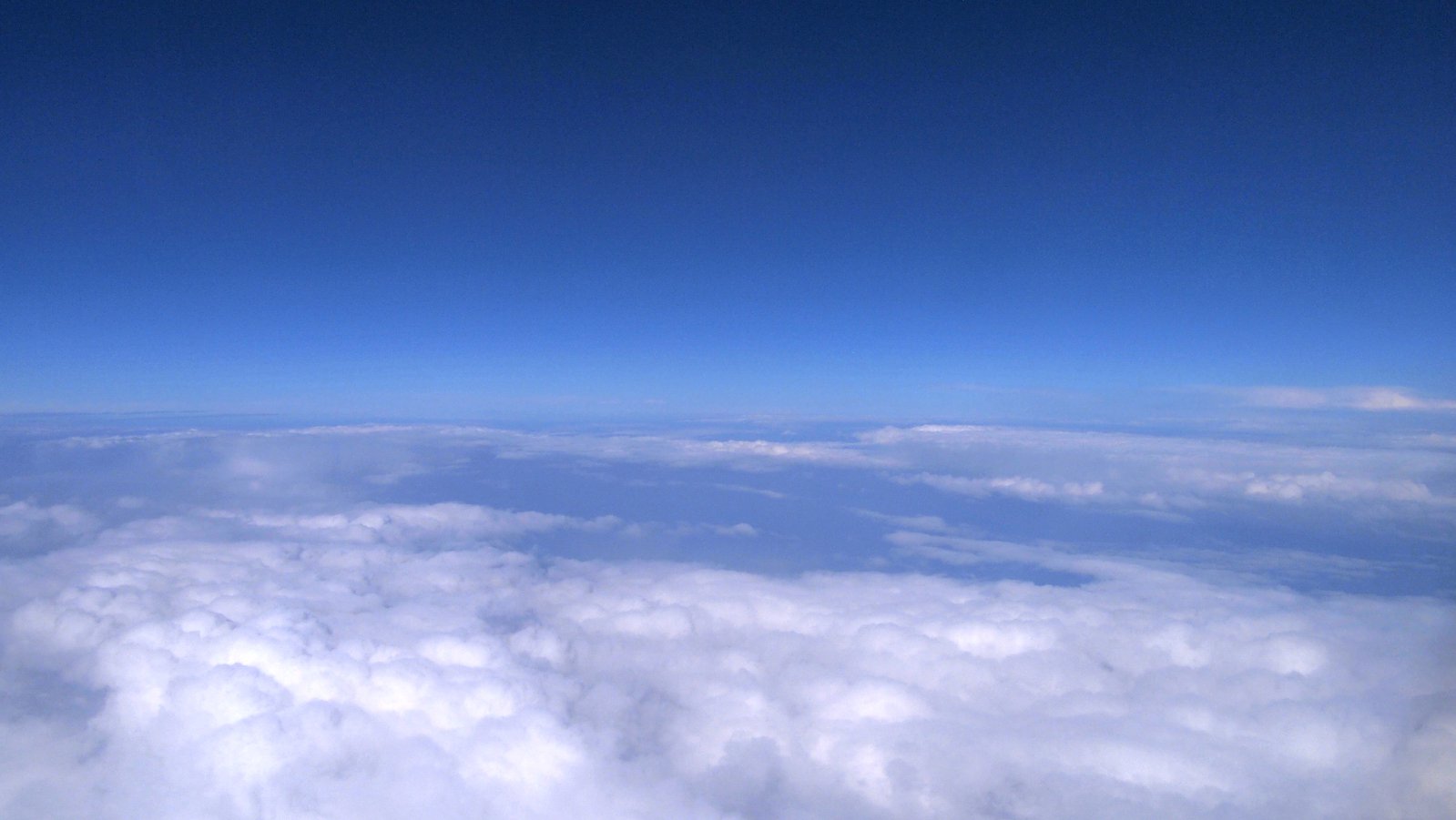 a cloud covered area with bright blue sky above