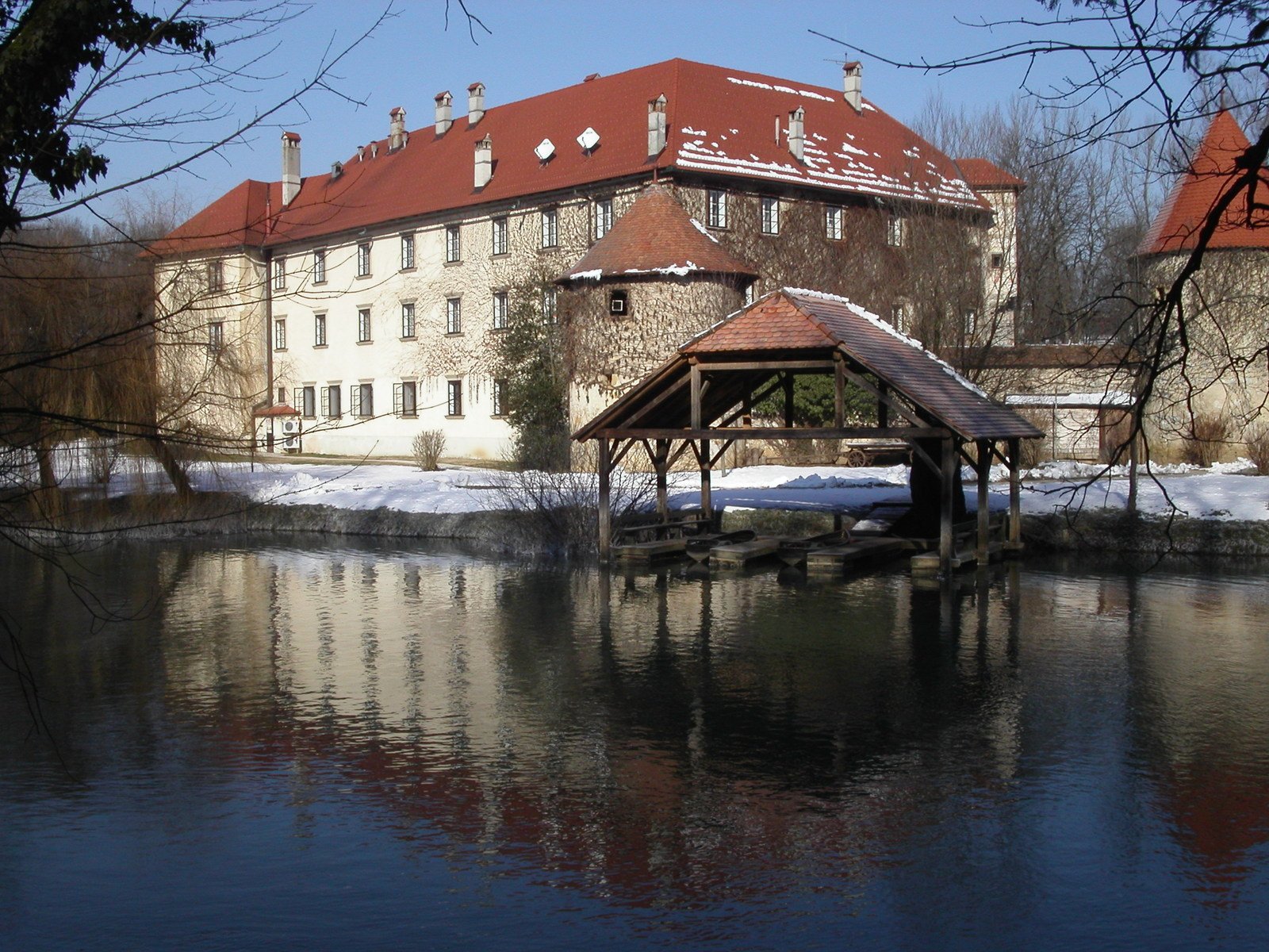 a building sitting in the middle of the water near a bridge