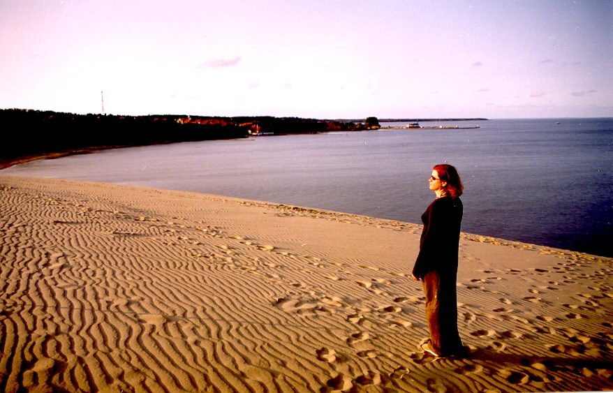 a woman standing on top of a sandy beach