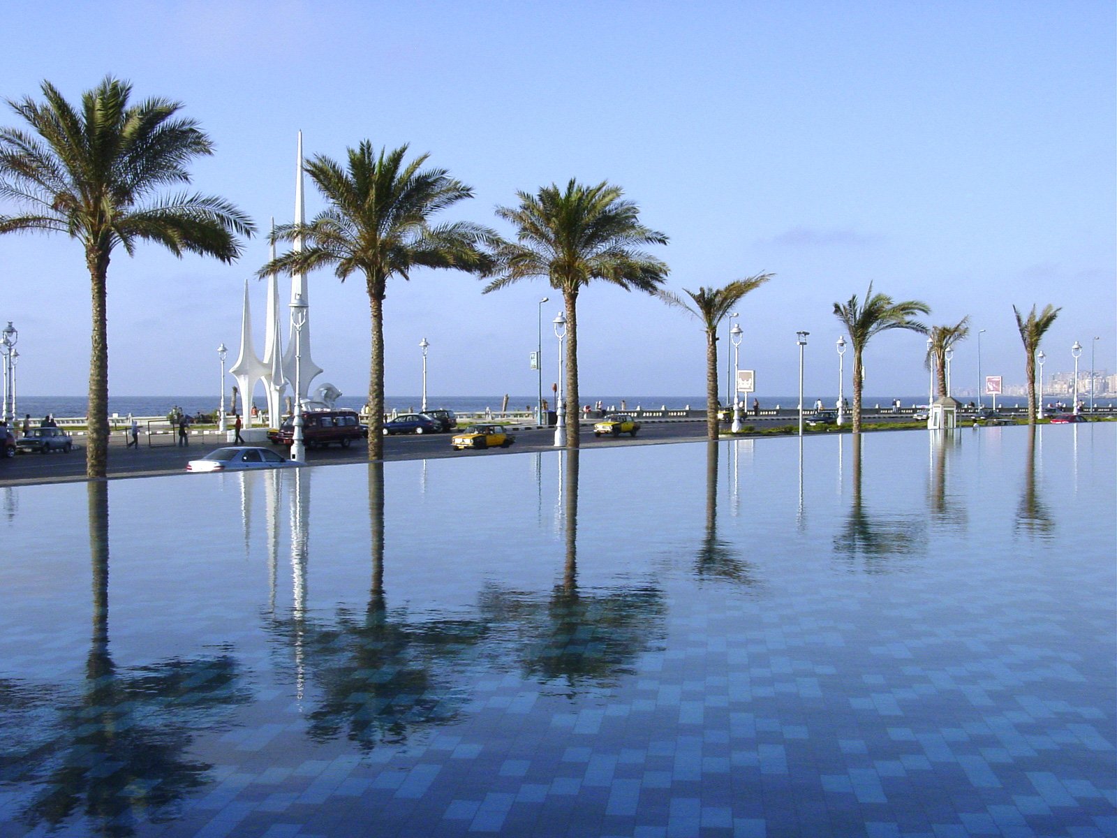 a long pool filled with water and palm trees