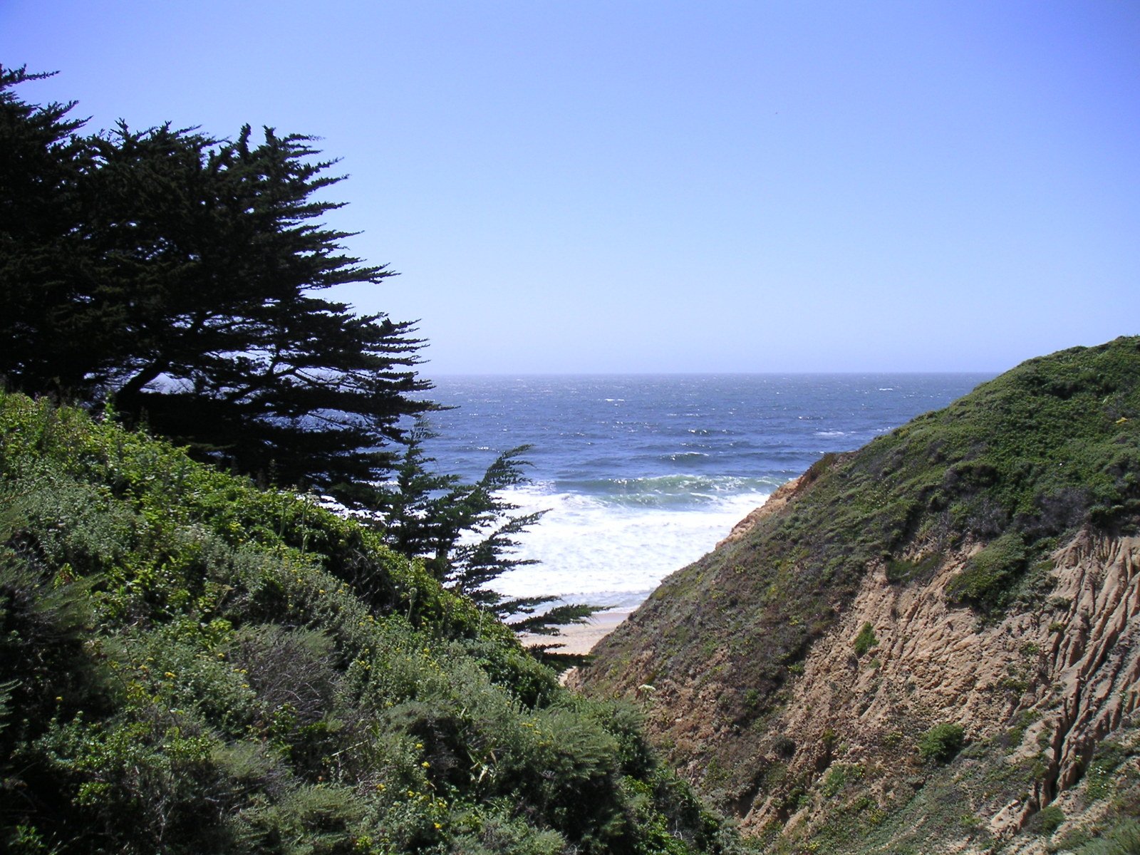 a view of a cliff and the ocean near a beach