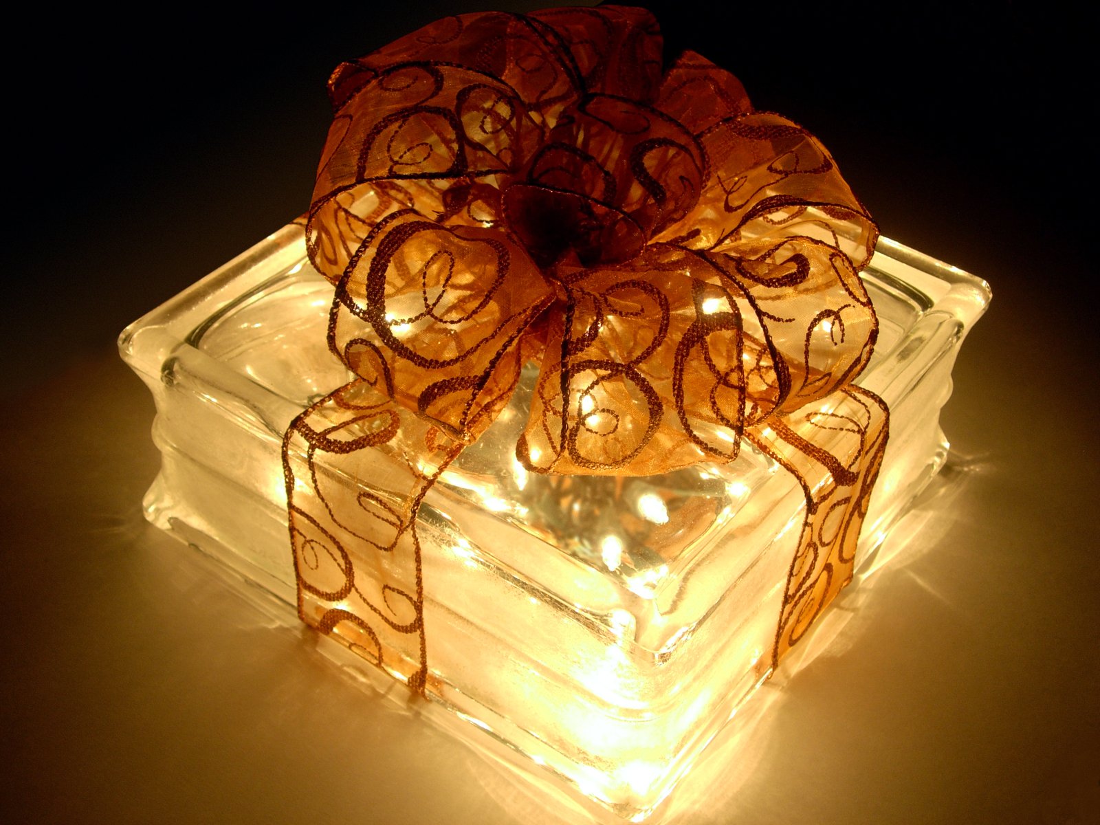 lighted square light decoration on table with orange ribbon