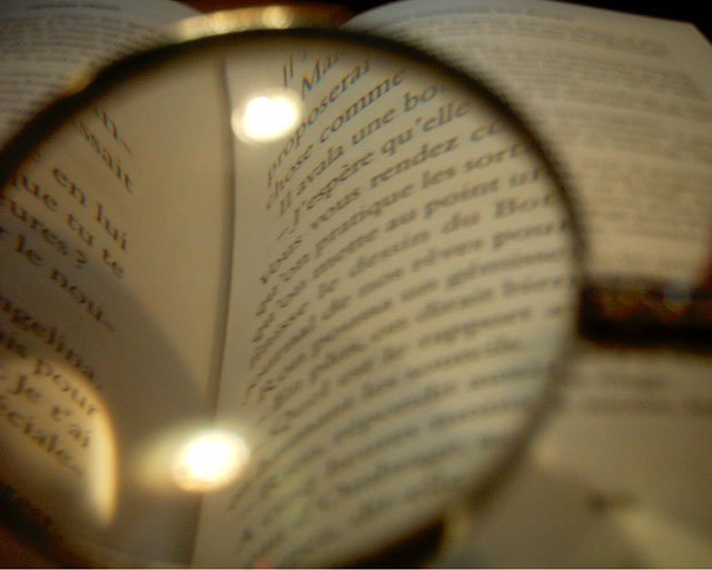 a close up of a book's light and reading glasses