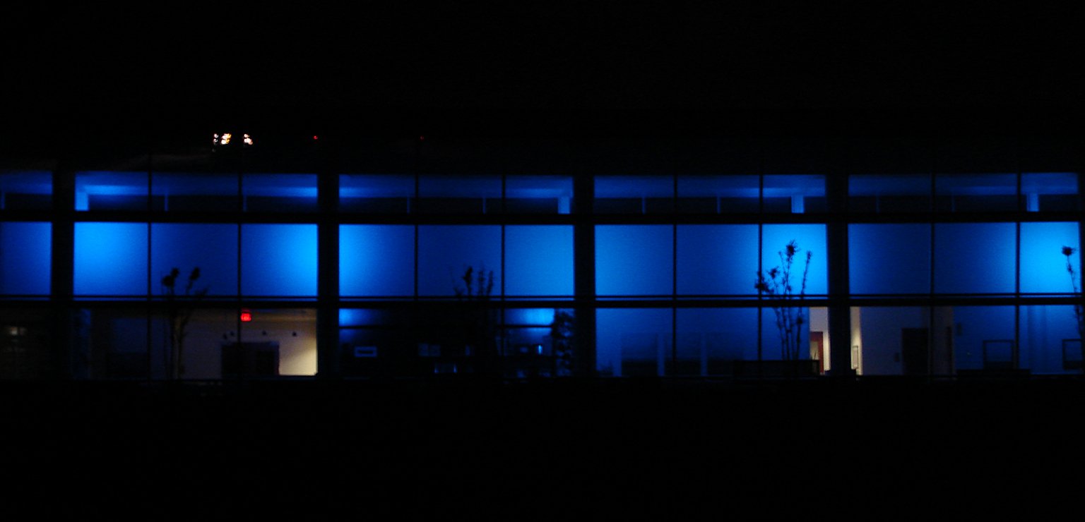 windows lit up in blue at night with the lights on