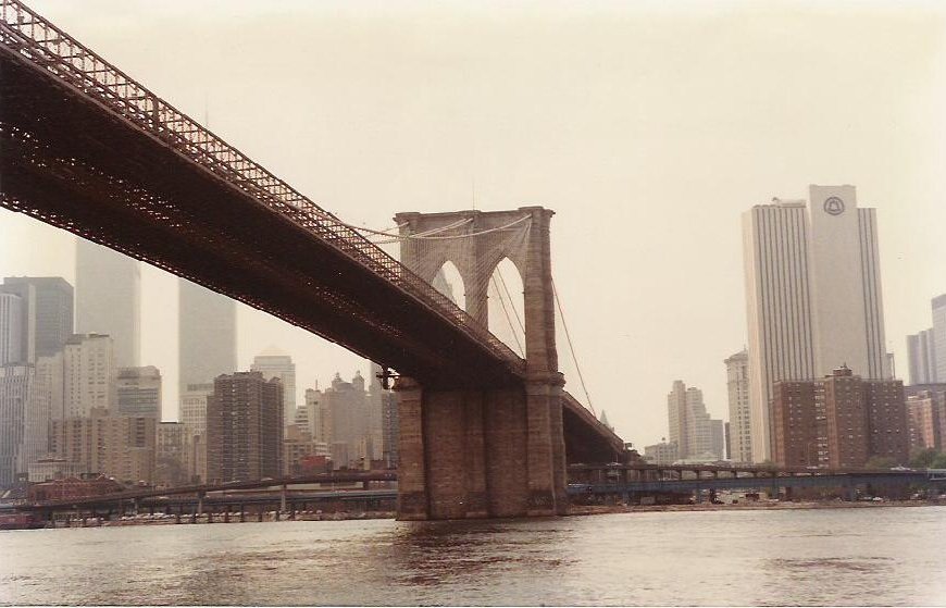 a bridge over a river with tall buildings in the background