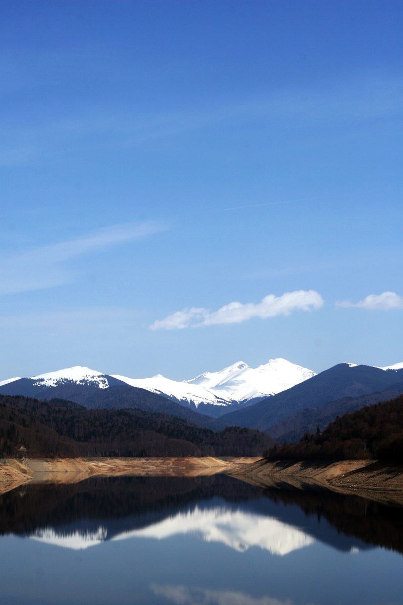 the beautiful landscape shows a lake, mountains and clouds