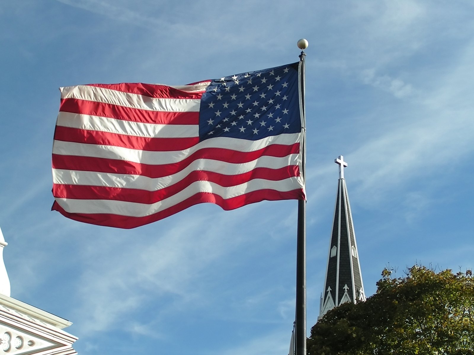 an american and european flag wave in the wind