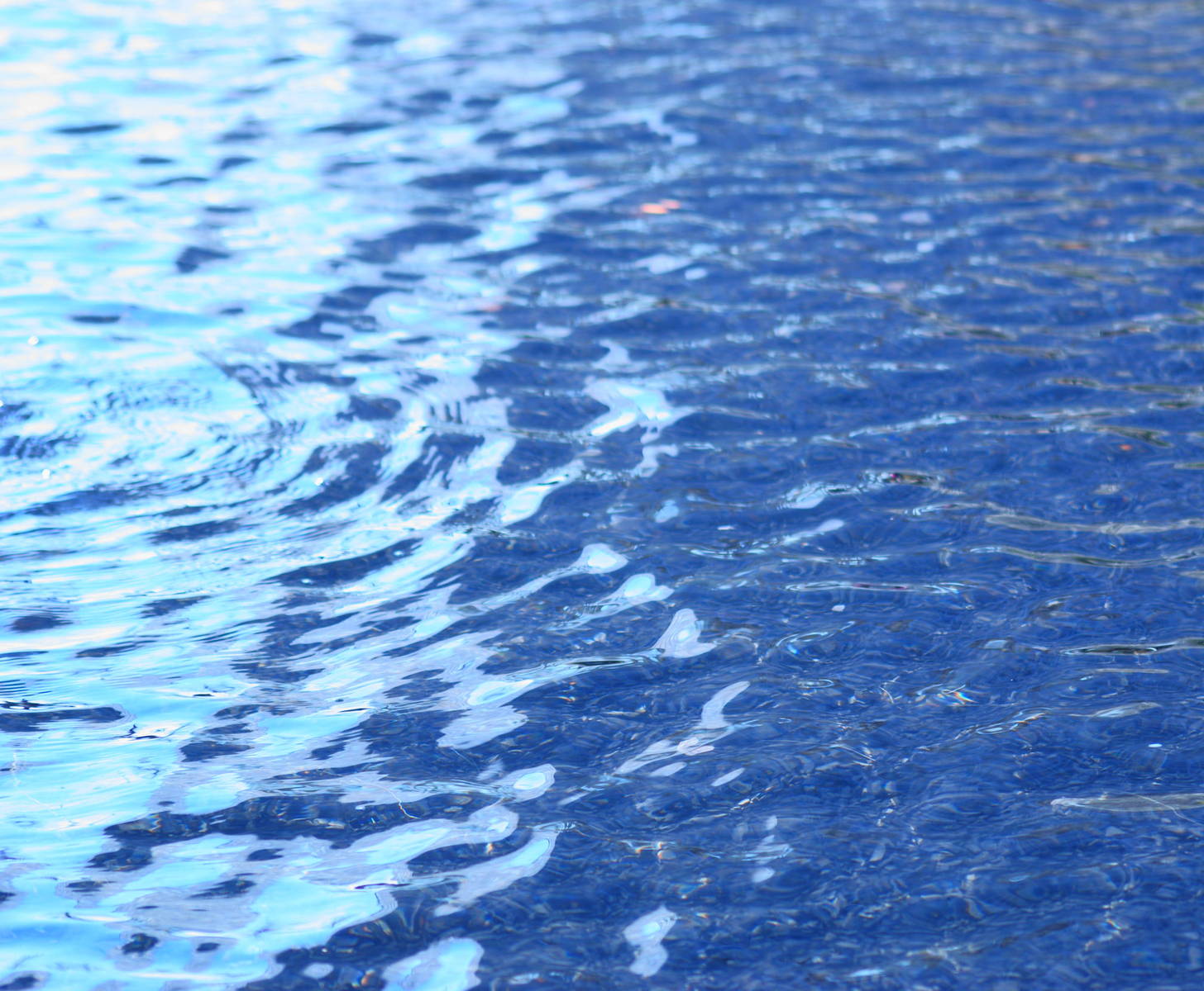 some water that is reflecting the sky and sunlight