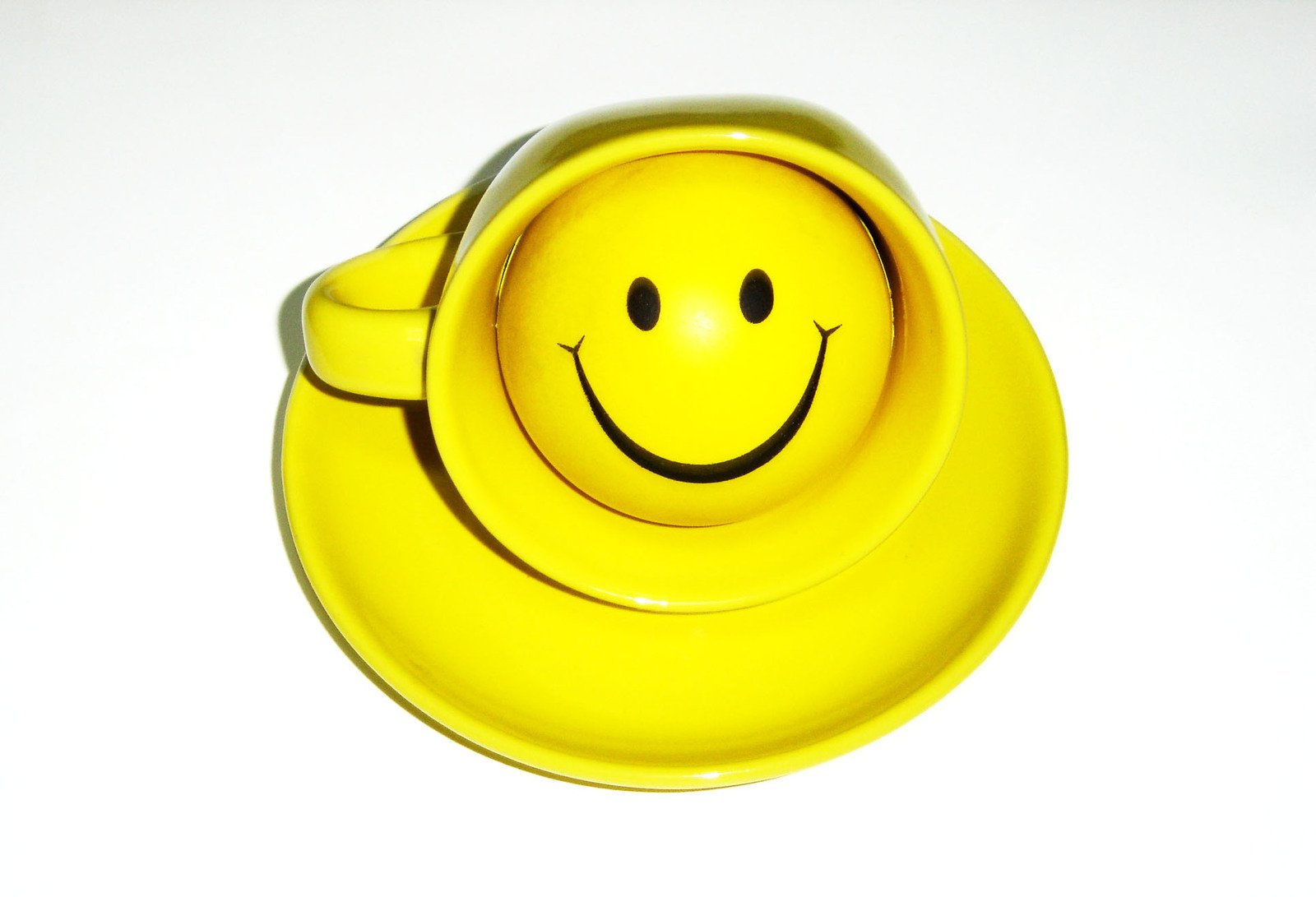 a yellow bowl on top of a white surface