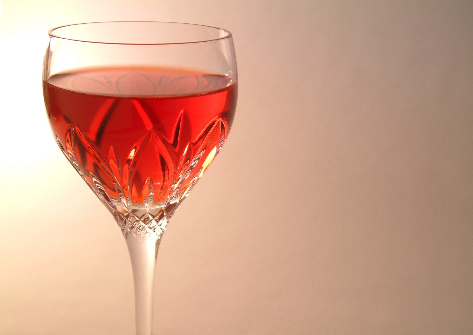 a wine glass filled with red liquid on top of a table