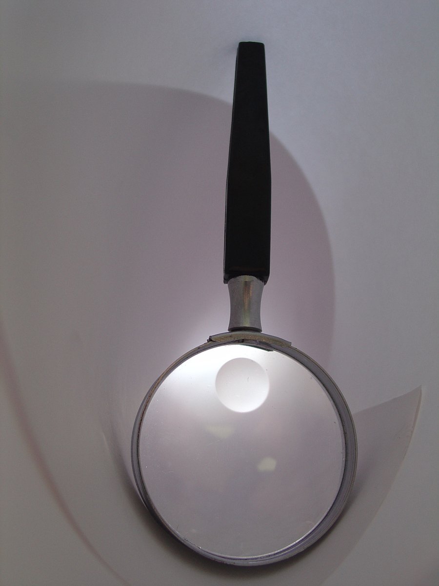 a magnifying glass mounted on a white wall
