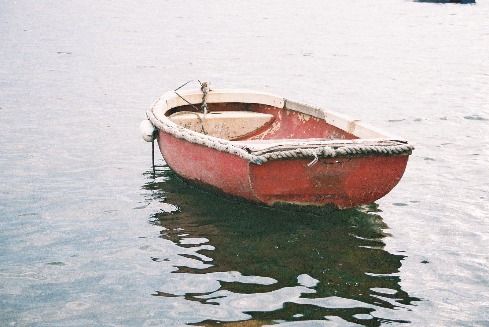 a red boat on the shore with other boats