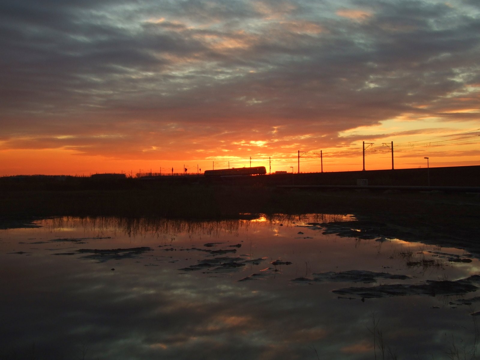 the sun is setting over a flooded landscape