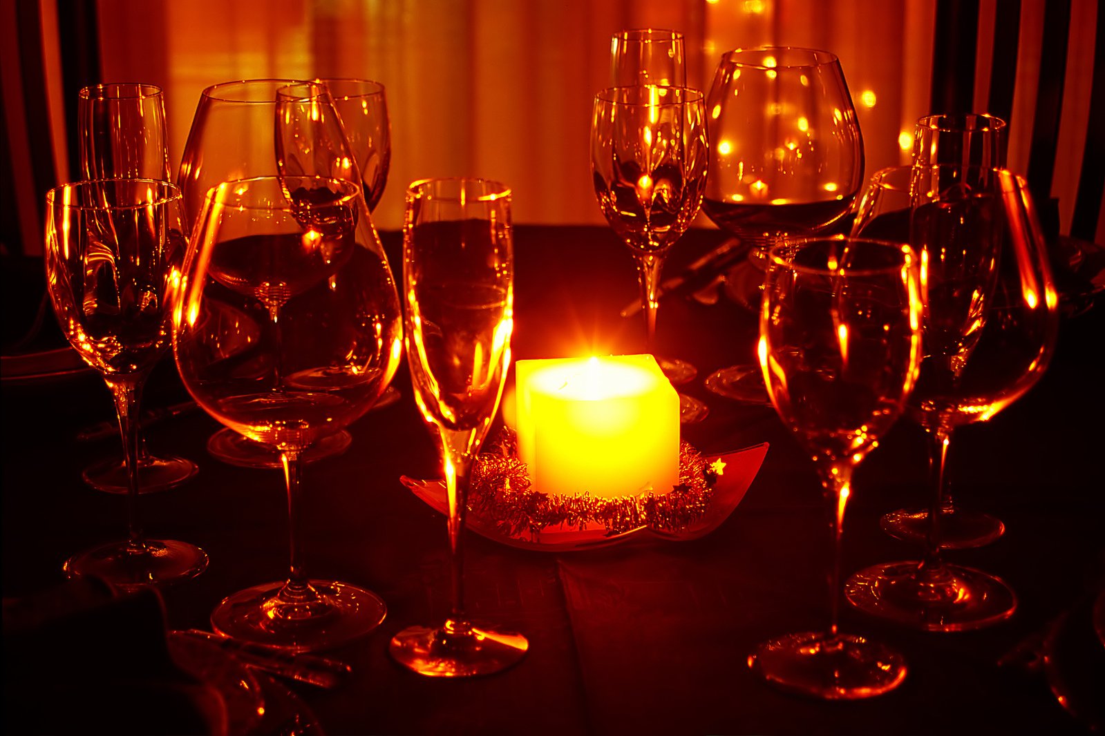 some glasses and candles sit on the table
