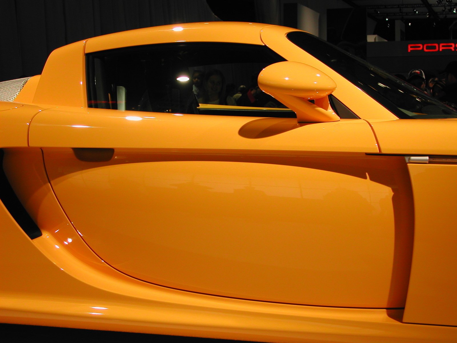 a yellow sports car is on display at a convention