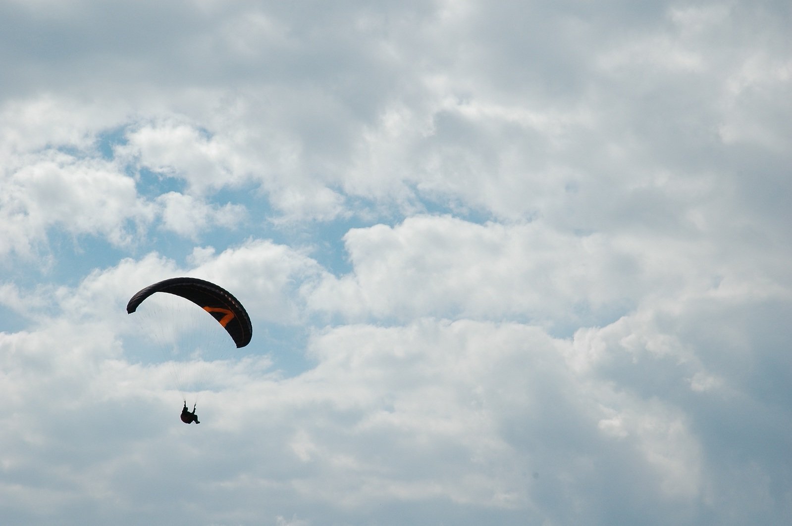 two people in the middle of a big sky with kites in it