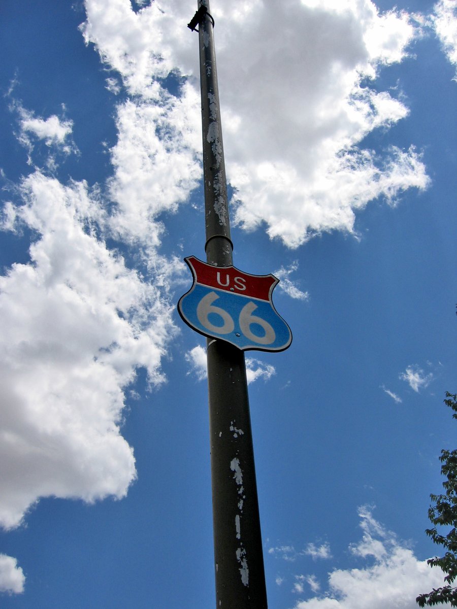 a road sign on a pole under cloudy skies