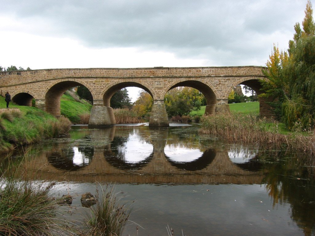 a bridge spanning over a small river in a park