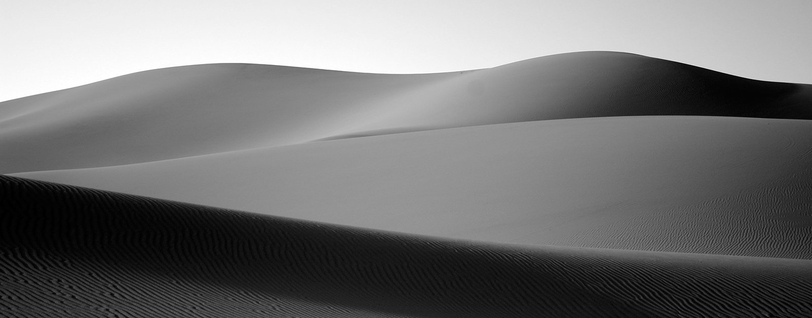 a black and white image of sand dunes
