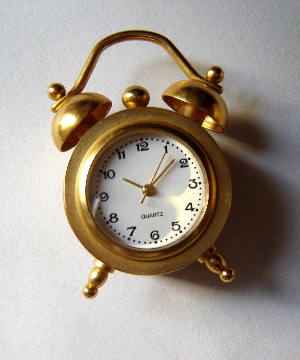 an old gold clock with bells on it