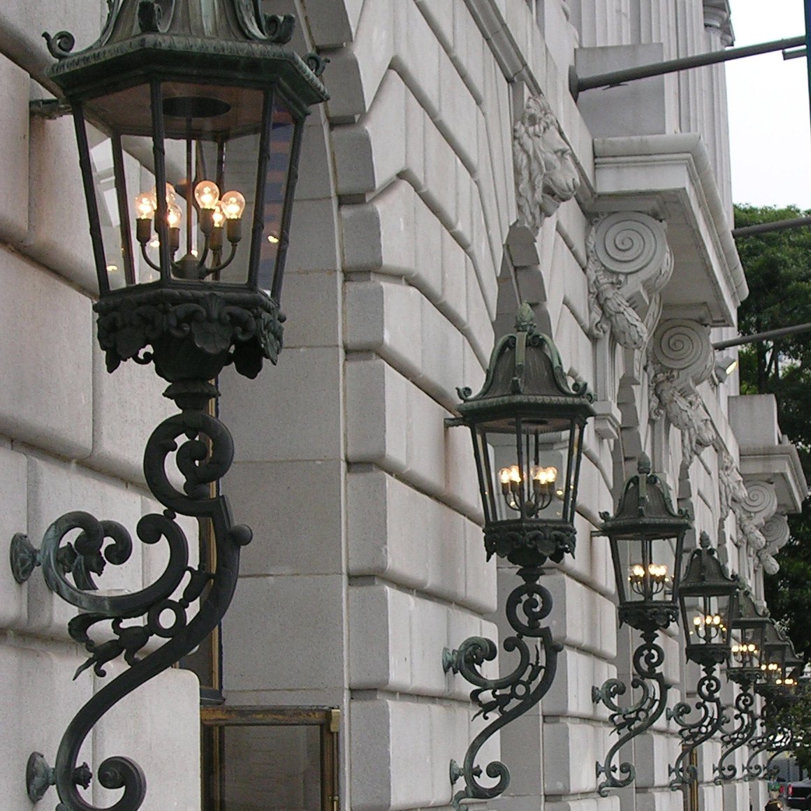 streetlights in an old fashioned architecture line the stone facade of a historic building