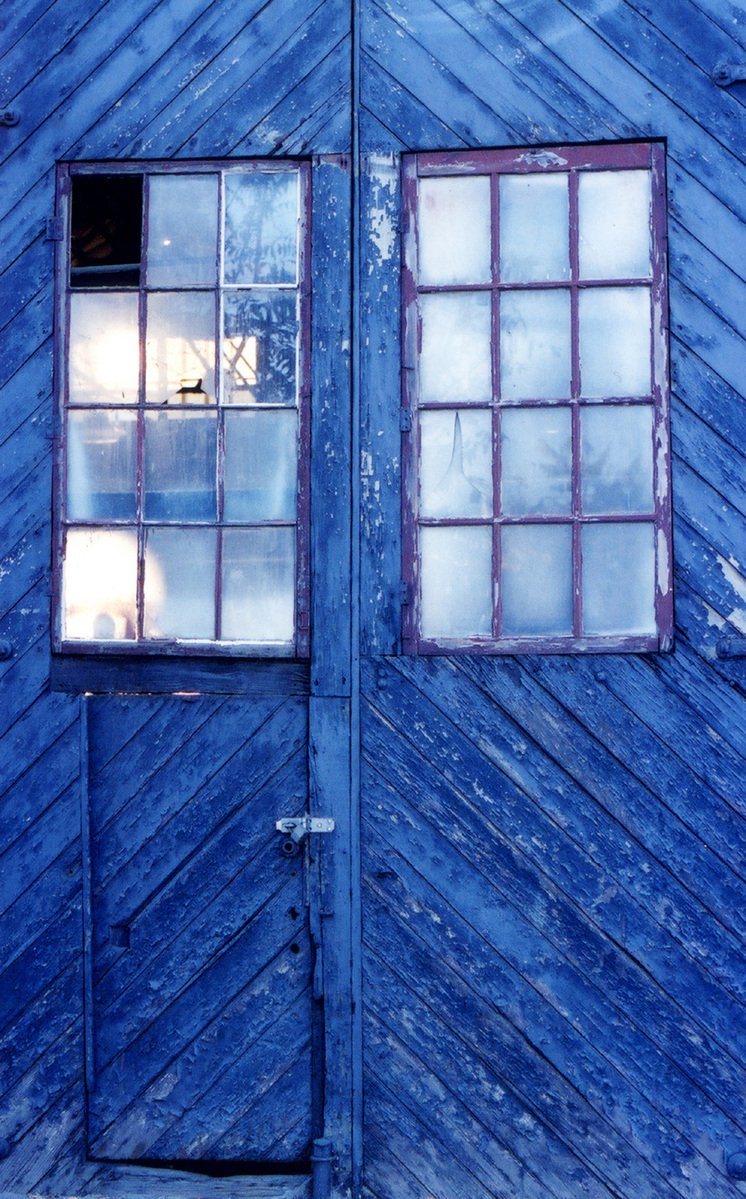 a blue wall with a few windows on top of it