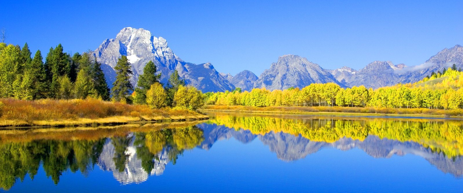 the mountains are reflected in a body of water