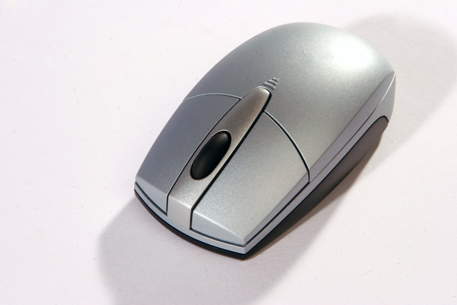 a silver computer mouse on a white surface