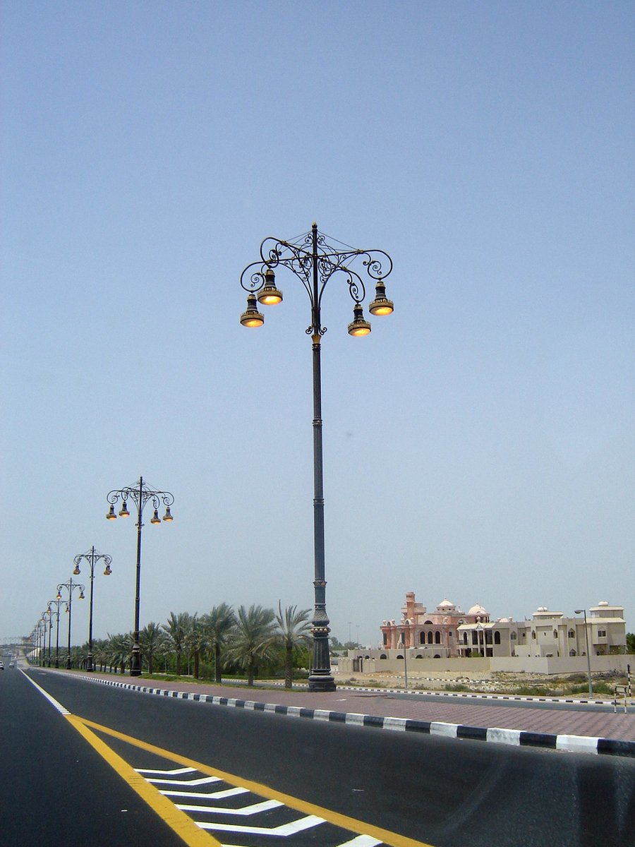 street lights are standing beside an empty road
