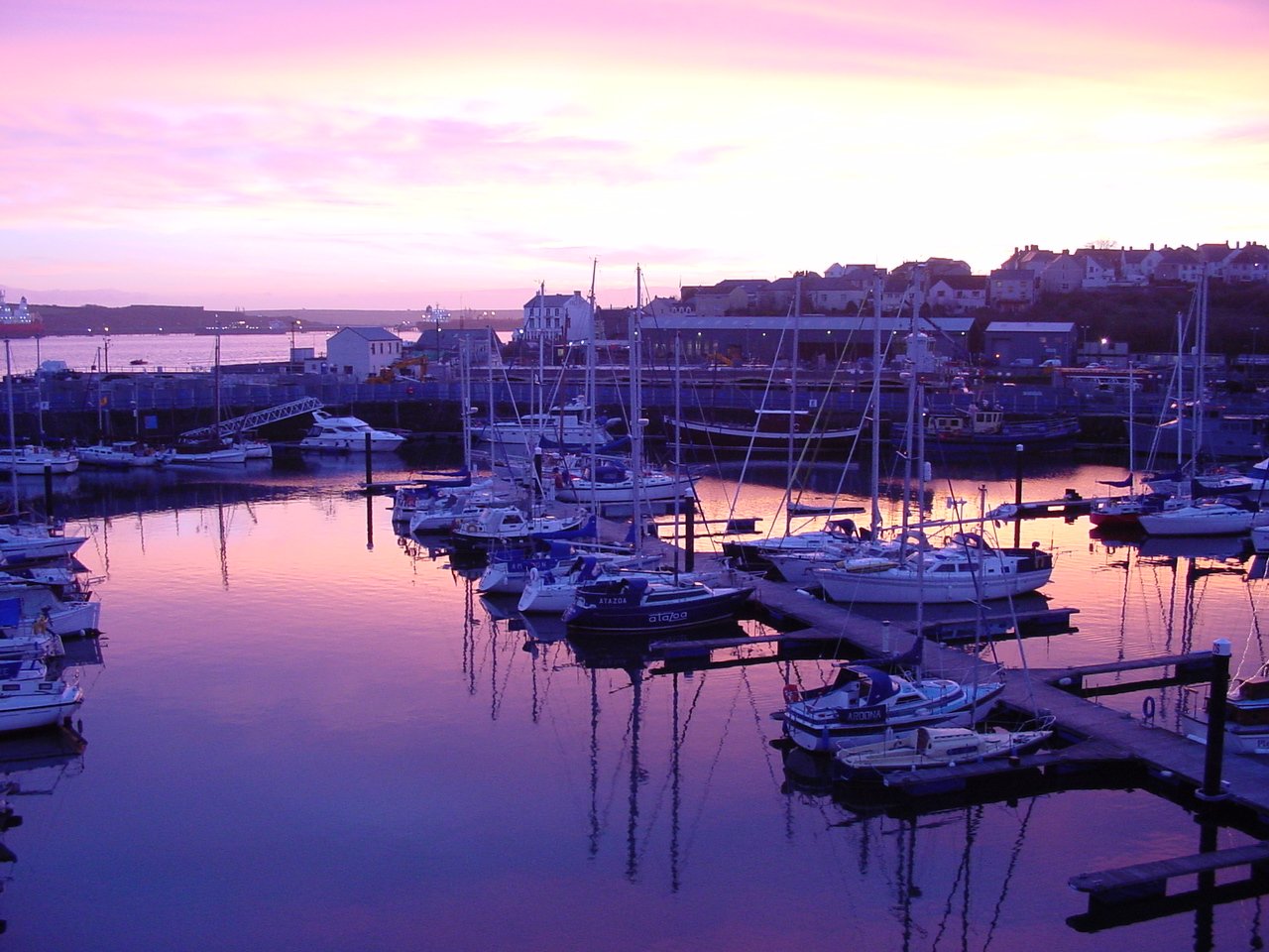 many boats sitting on the water at dusk