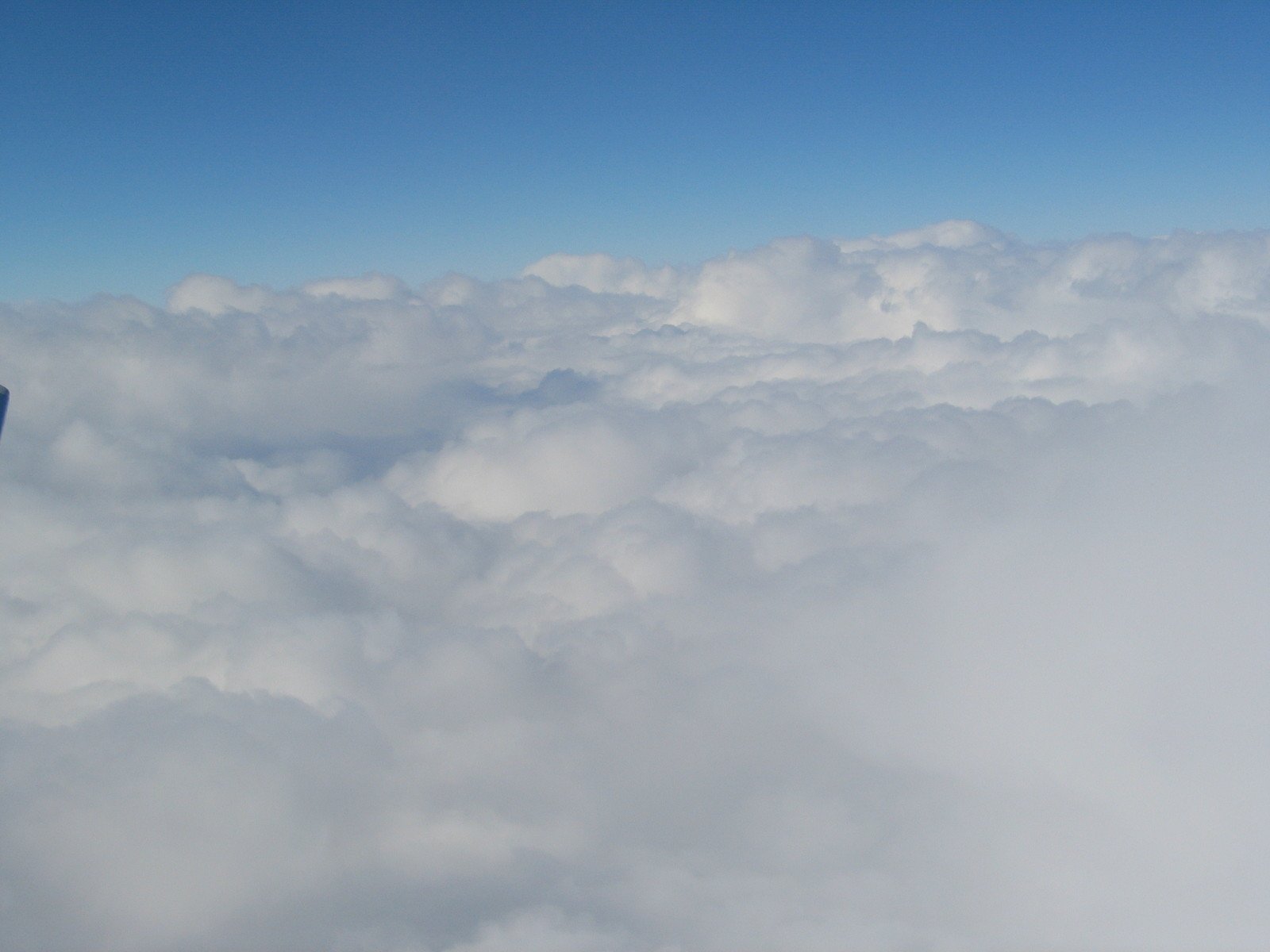 an airplane is flying over some clouds