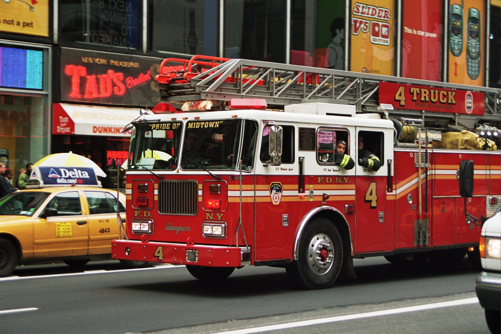 a red fire truck driving past tall buildings