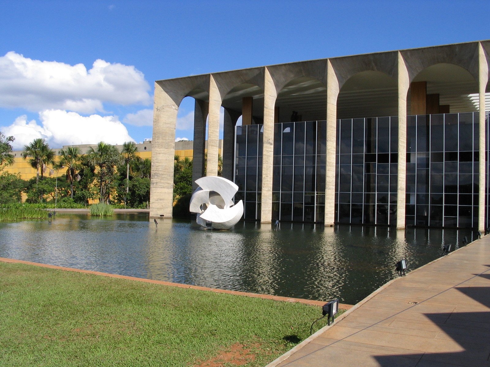 a building next to the water and the top of it is leaning backwards